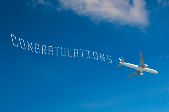Airplane with "Congratulations" trailed it in sky writing