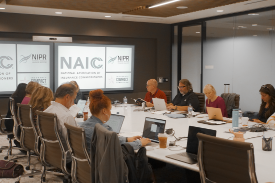 Compact staff gathered around a long conference room table
