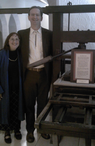 Man and woman standing next to a printing press