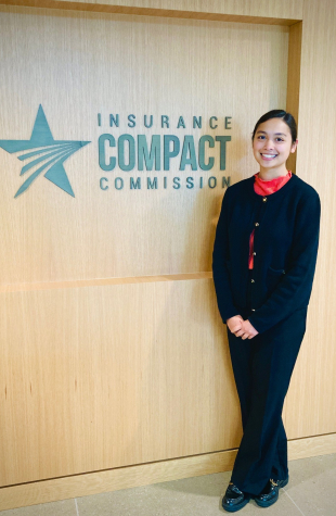Hannah Um standing in front of Compact logo at the KC office location